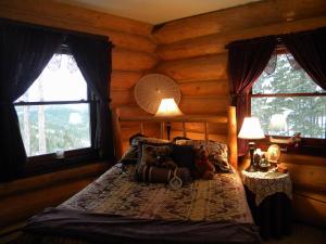 1 dormitorio con 1 cama en una cabaña de madera en The Garrison Inn a Montana Bed & Breakfast, en Kalispell