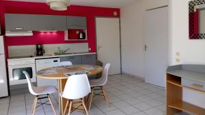 a kitchen with a wooden table and white chairs at Les Clés Nature in Moutiers-sous-Chantemerle