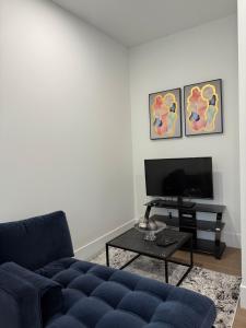 a living room with a blue couch and a tv at Calm & Cozy Private Suite in Surrey +3 photos