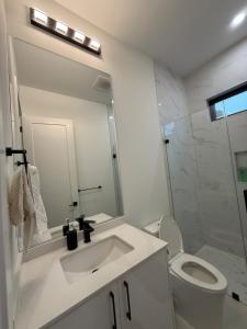 a white bathroom with a sink and a toilet at Calm & Cozy Private Suite in Surrey