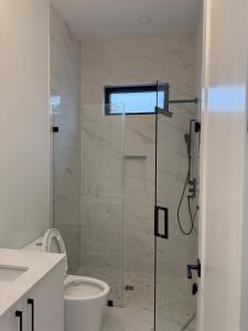 a bathroom with a glass shower with a toilet at Calm & Cozy Private Suite in Surrey