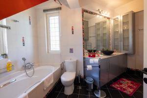 Un baño con bañera, inodoro y lavabo. en Virginia's Art House, en Porto Rafti