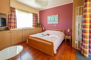 1 dormitorio con 1 cama con paredes rojas en Virginia's Art House, en Porto Rafti