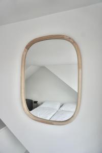 a mirror hanging on a wall with a bed at Bed & Beach 114 in Noordwijk aan Zee +17 photos