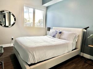a bedroom with a large white bed with a window at Large Hollywood Corner 2 Bedroom with Private Balcony in Los Angeles +25 photos