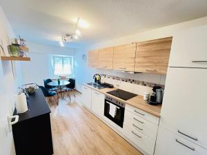 a kitchen with white cabinets and a table in it at Schwarzwaldnest Donaueschingen in Donaueschingen