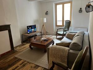 Una sala de estar con un sofá y una mesa de café. en Maison familiale des remparts, en Colmars