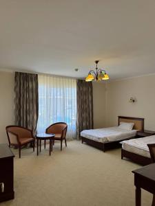 ein Hotelzimmer mit zwei Betten und einem Tisch und Stühlen in der Unterkunft Family cottage in Bosteri + 33 Fotos