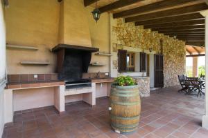 an outdoor kitchen with a stove and a barrel at S'hort, espectacular villa en el paraíso in Calonge