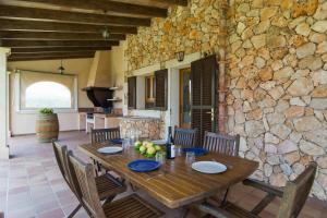 a dining room with a table and a stone wall at S'hort, espectacular villa en el paraíso in Calonge