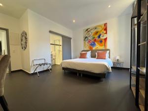 a bedroom with a bed and a painting on the wall at Hotel La Cigale in La Croix-Valmer +26 photos