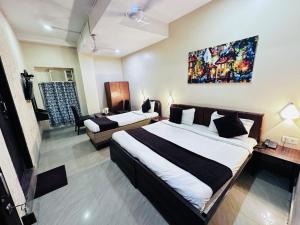 a bedroom with two beds and a living room at The Garden inn Varanasi in Varanasi +18 photos