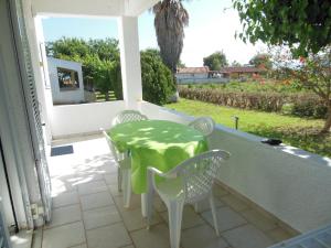 a patio with a table and chairs on a balcony at Helonata Apartments in Arkoudi