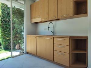 a kitchen with wooden cabinets and a sink at Capo Ceraso Family Resort in Costa Corallina
