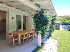 a wooden table and chairs on a patio at Capo Ceraso Family Resort in Costa Corallina