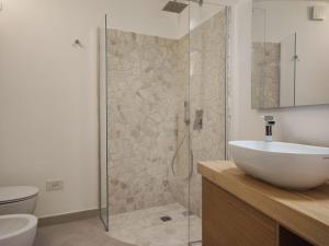 a bathroom with a sink and a glass shower at Capo Ceraso Family Resort in Costa Corallina