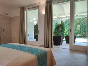 a bedroom with a bed and sliding glass doors at Capo Ceraso Family Resort in Costa Corallina