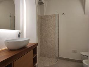 a bathroom with a sink and a glass shower at Capo Ceraso Family Resort in Costa Corallina