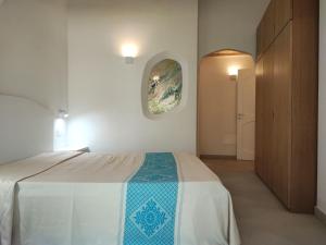 a bedroom with a bed and a painting on the wall at Capo Ceraso Family Resort in Costa Corallina