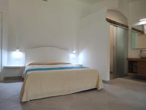 a bedroom with a large bed in a room at Capo Ceraso Family Resort in Costa Corallina