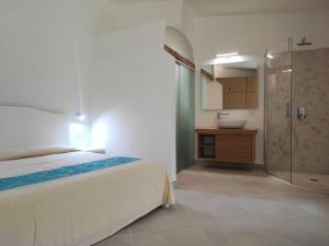 a bedroom with a bed and a shower and a sink at Capo Ceraso Family Resort in Costa Corallina