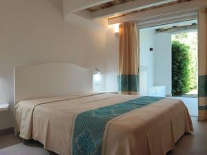 a bedroom with a bed and a large window at Capo Ceraso Family Resort in Costa Corallina