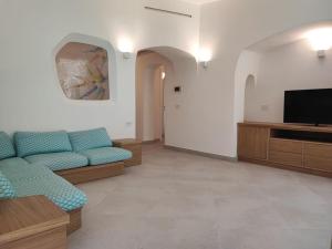 a living room with a couch and a flat screen tv at Capo Ceraso Family Resort in Costa Corallina