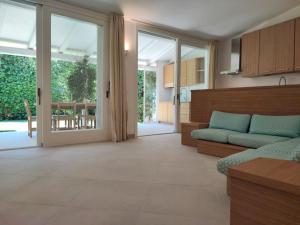 a living room with a couch and sliding glass doors at Capo Ceraso Family Resort in Costa Corallina