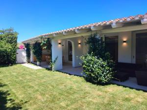 a house with a green yard with a house at Capo Ceraso Family Resort in Costa Corallina