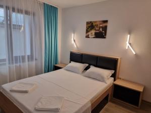 a bedroom with a large bed with two pillows at EfoRooms - Apartamente si Camere moderne in Eforie Nord