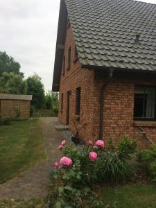 a brick house with pink flowers in front of it at Fewo Lukas in Polchow
