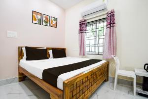 un dormitorio con una cama y una ventana en Hotel O Shree Jagannath Residency, en Khandagiri