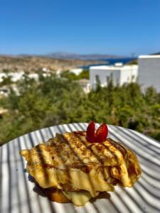 Un trozo de comida con dos cerezas en un plato. en Speires suites, en Iraklia