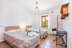 a bedroom with two beds and a chair at S'hort, espectacular villa en el paraíso in Calonge +30 photos