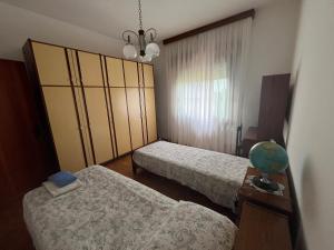 Altivoleにあるcasa Giovannaのベッドルーム1室(ベッド2台、ランプ付きテーブル付)