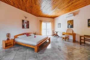 a bedroom with a bed and a wooden ceiling at Villa Arcadia in Nosy Be +32 photos