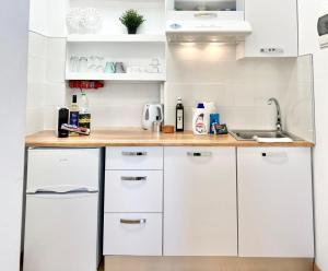 a white kitchen with white cabinets and a sink at Golden Beach, Little Troll House 3 in Chrissi Akti