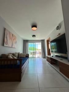 ein Wohnzimmer mit Sofa und Flachbildfernseher in der Unterkunft Cobertura na praia in Arraial do Cabo