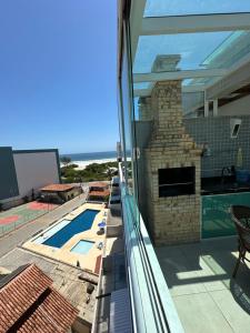 Blick vom Balkon eines Hauses mit Swimmingpool in der Unterkunft Cobertura na praia in Arraial do Cabo