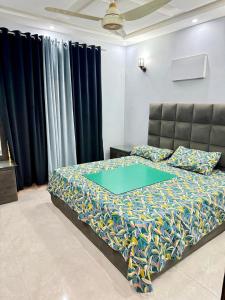 a bedroom with a bed with a blue comforter at Malik House Bahria town Karachi, Ali block in Karachi