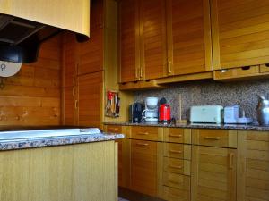 a kitchen with wooden cabinets and a counter top at Chalet aux Coches 10 pers. | 7 min des pistes, internet et parking gratuits - FR-1-329-18 in Bellentre +9 photos