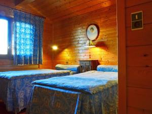 a bedroom with three beds in a wooden cabin at Chalet aux Coches 10 pers. | 7 min des pistes, internet et parking gratuits - FR-1-329-18 in Bellentre