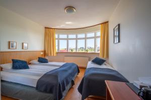 海德利桑德Adventure Hotel Hellissandur的有两张床和一扇窗户的卧室