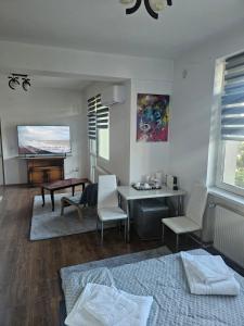 a bedroom with a bed and a table and chairs at SMB home PANORAMA in Oradea