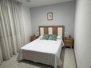 sypialnia z białym łóżkiem i 2 szafkami nocnymi w obiekcie Casa Fuentes w mieście Poio