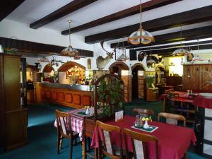 a restaurant with a red table and chairs and a counter at Penzion Rožič in Bohinj