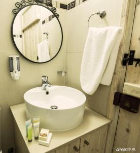 bagno con lavandino bianco e specchio di Anastou's Traditional House a Kalopanayiotis