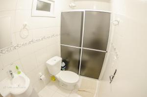 a bathroom with a shower and a toilet and a sink at Pousada Landhaus in Urubici