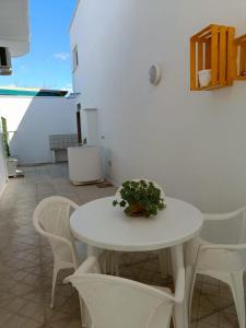 a white table and chairs with a plant on it at Casa vacanze 'Dalla Nonna' in Mesagne