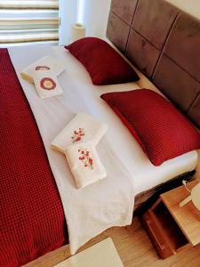 - un lit avec des couvertures et des oreillers rouges et blancs dans l'établissement D3-Zero free spa, à Veliko Gradište